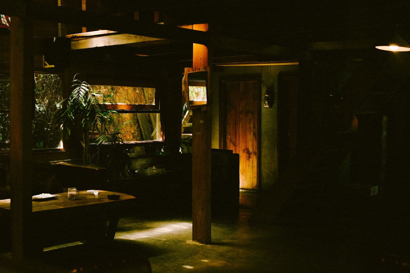 Dimly lit pub dining room with wooden tables and warm amber light