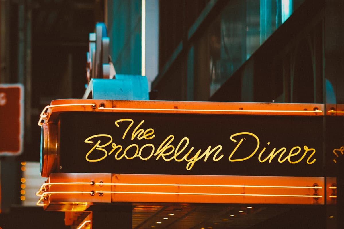A long table set for a group dinner at a New York City restaurant with warm lighting and wine glasses