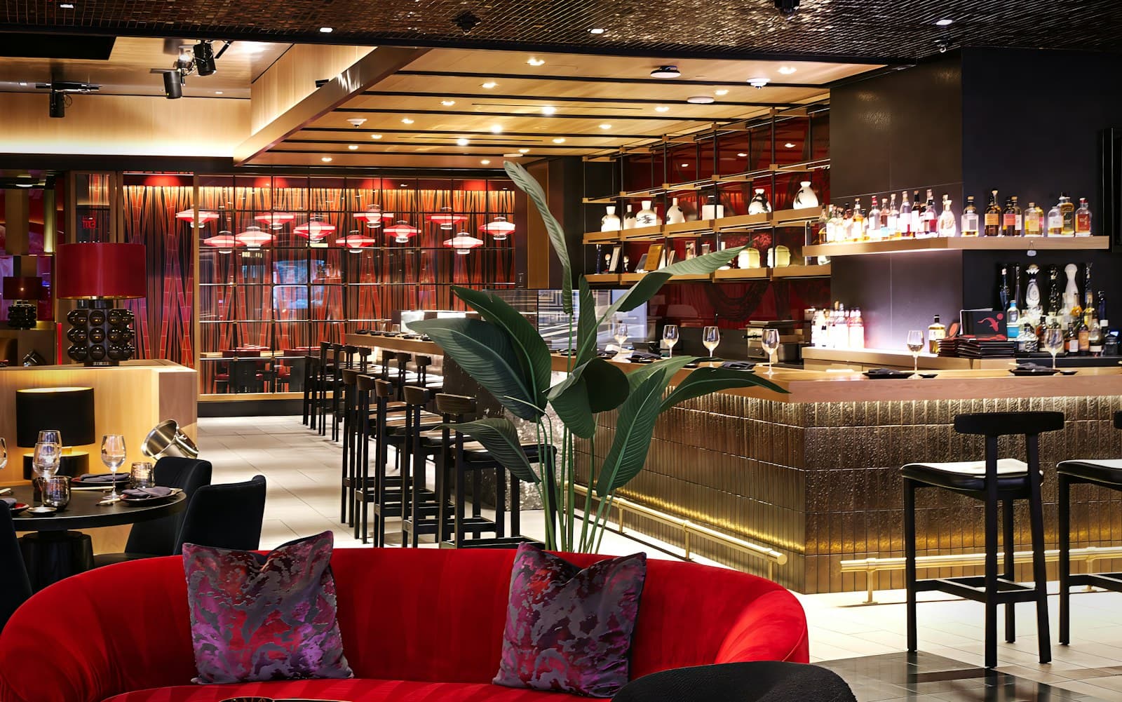 Elegant restaurant bar with red velvet seating and softly lit tables