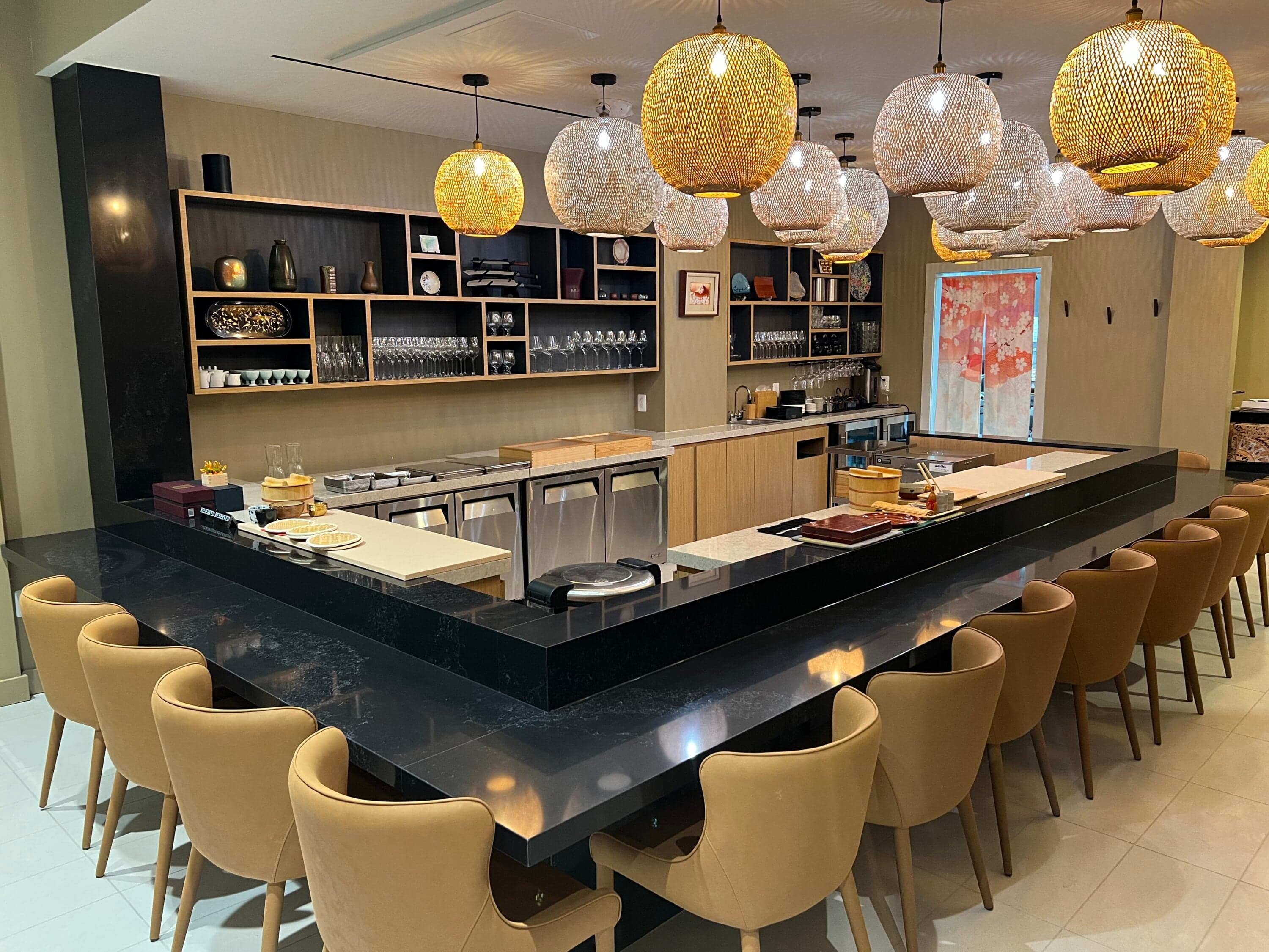 A minimalist sushi counter with polished wood seating and neatly plated nigiri