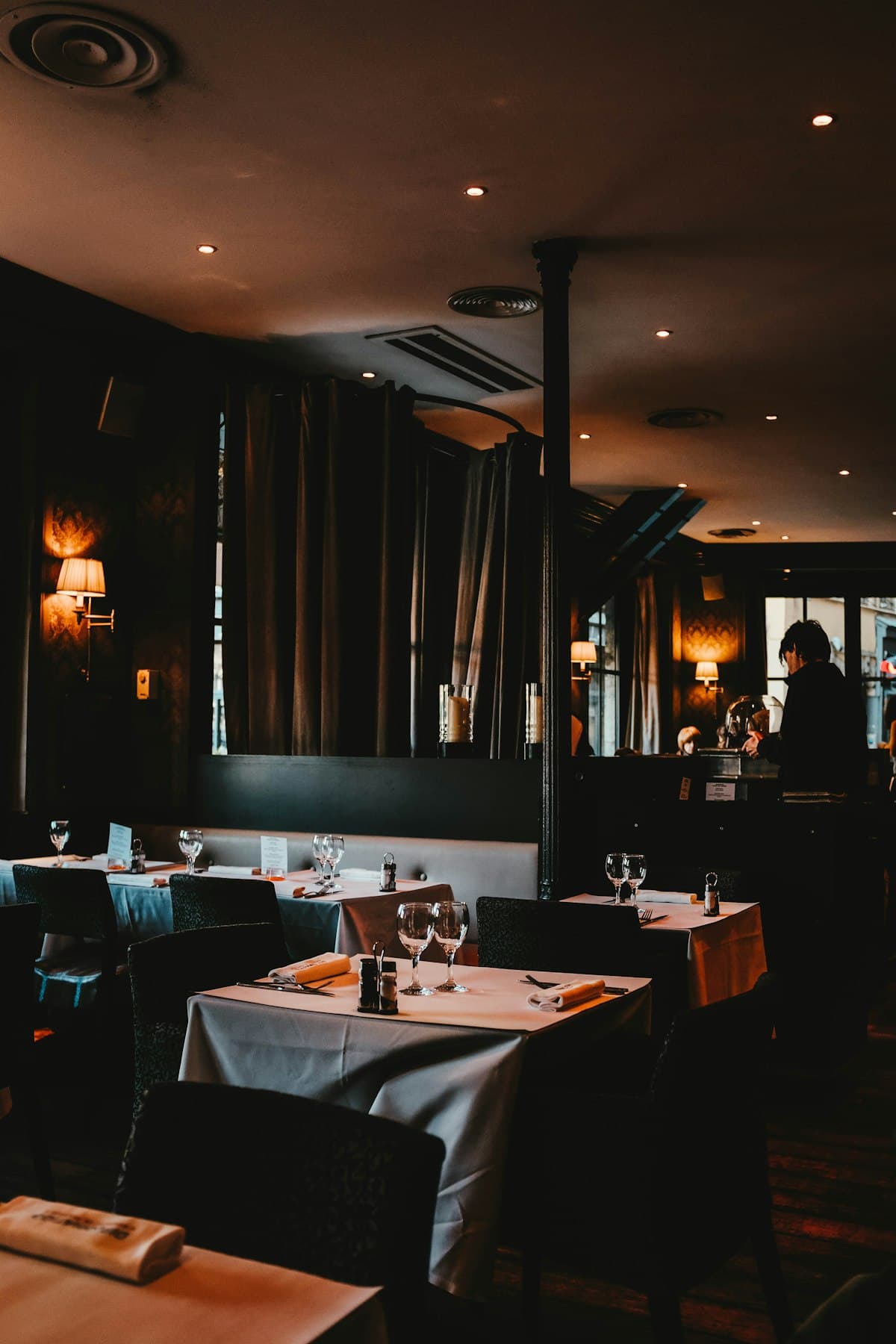 Warmly lit Los Angeles restaurant dining room prepared for evening service