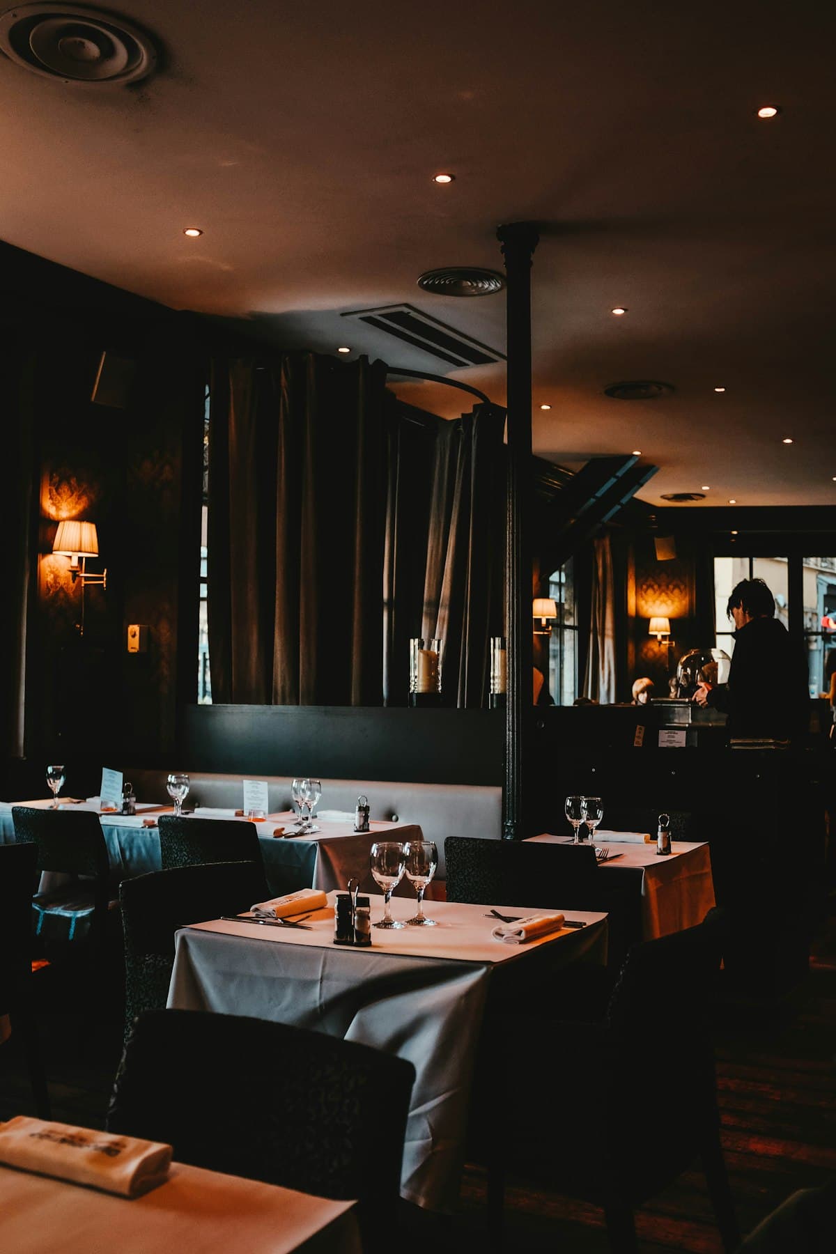 Warmly lit Los Angeles restaurant dining room prepared for dinner
