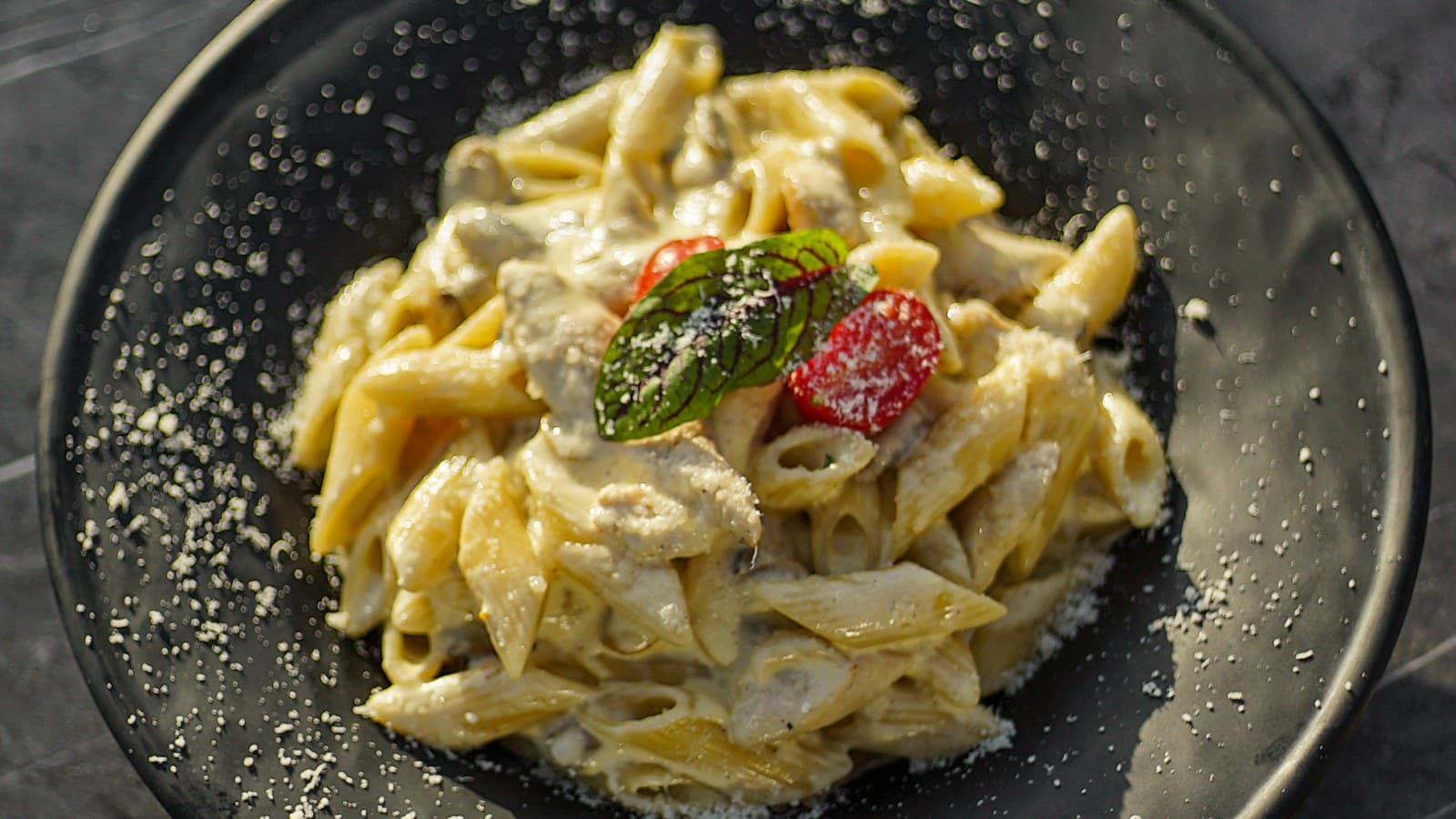 A plated pasta dish with grated cheese at an Italian restaurant