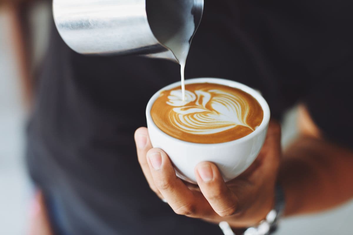 Freshly poured specialty coffee in a ceramic cup at a cafe counter