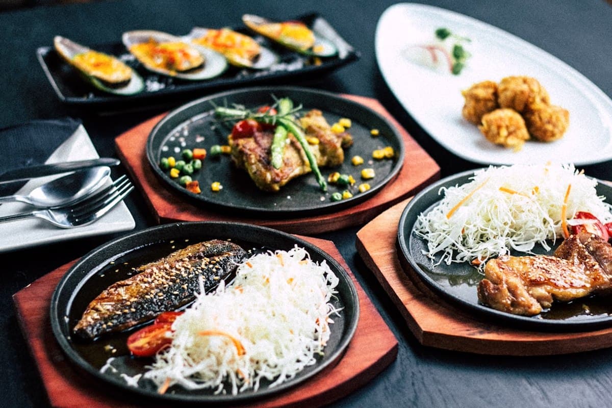 A busy San Francisco restaurant dining room with warm lighting and full tables