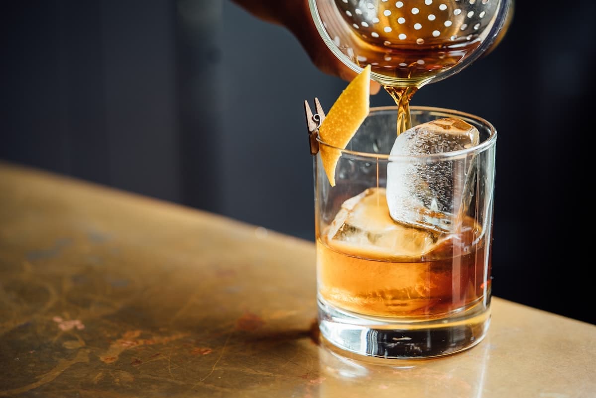 An intimate cocktail bar with warm lighting and bottles behind the counter