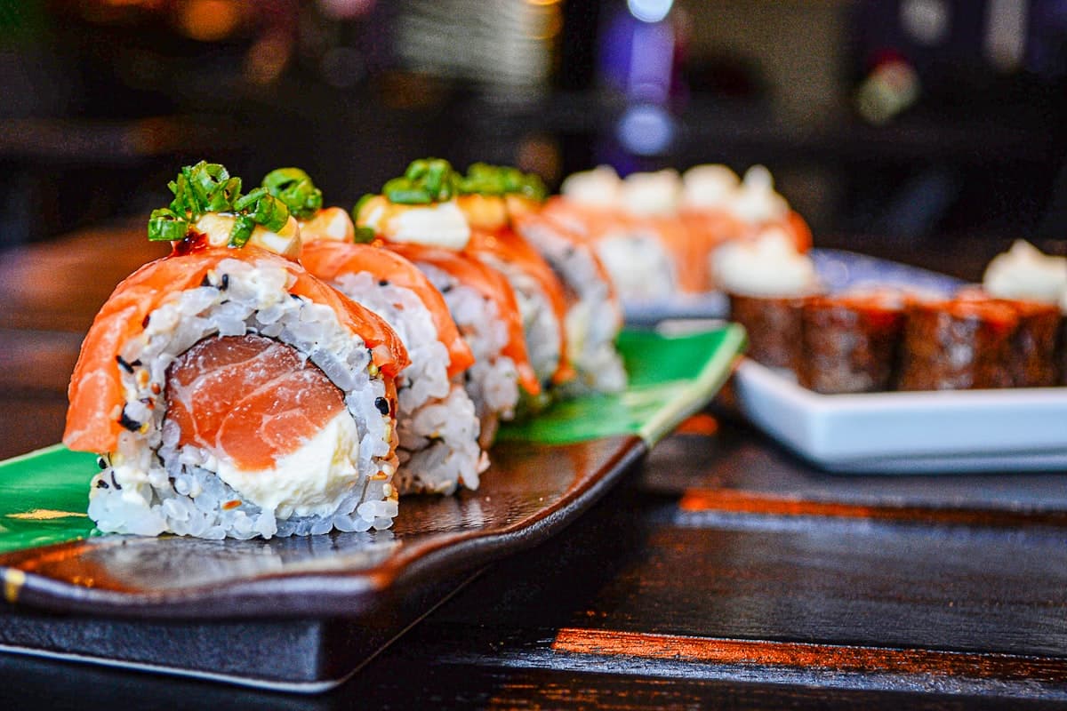 Elegant omakase sushi presentation on a dark counter with warm lighting