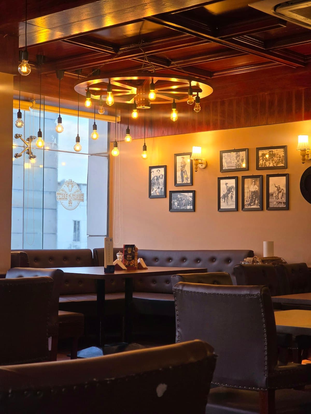 Warm restaurant dining room with guests, drinks, and golden evening lighting