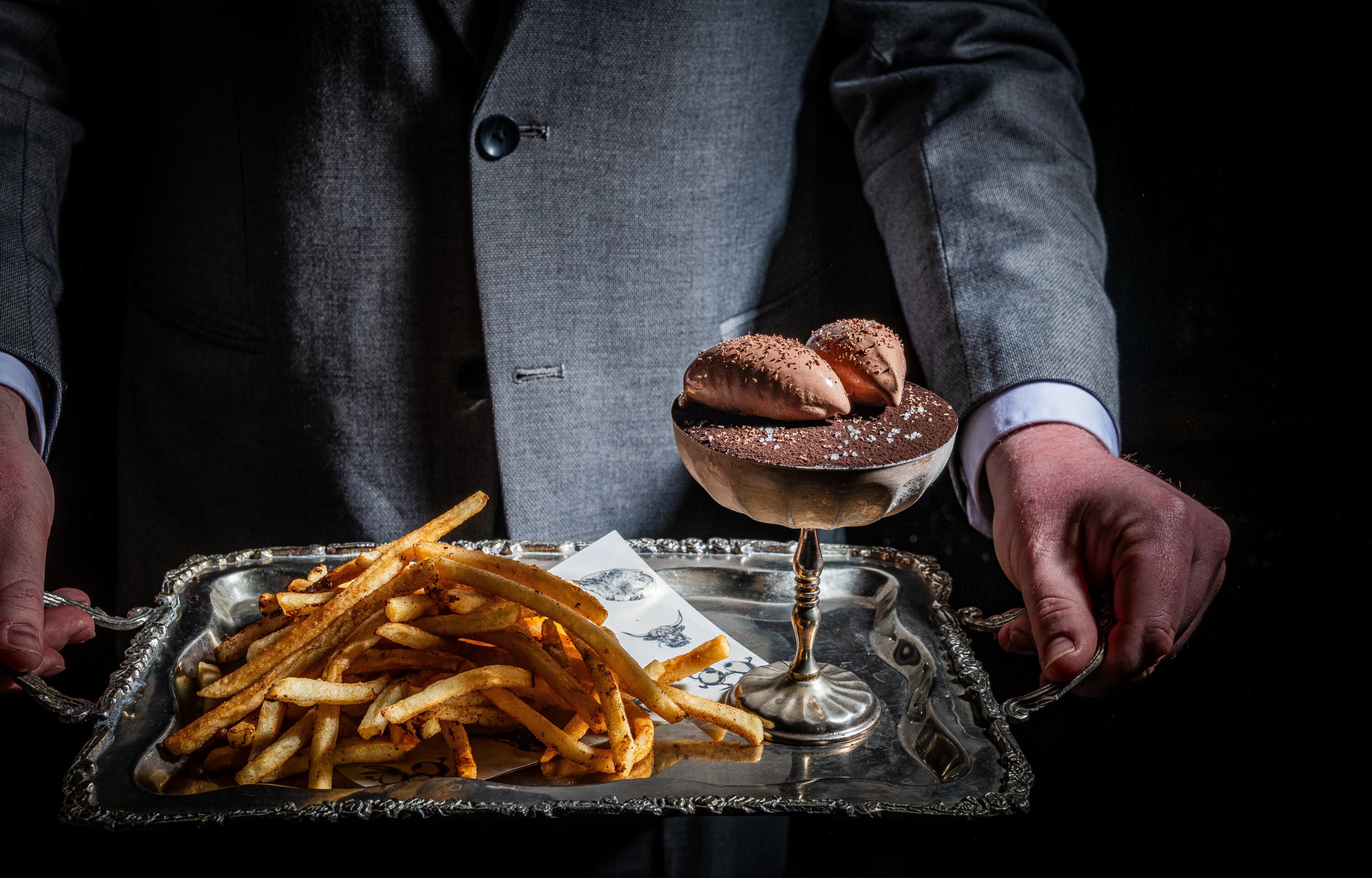 A polished restaurant bar with cocktails, warm lighting, and a lively Washington D.C. opening-night feel