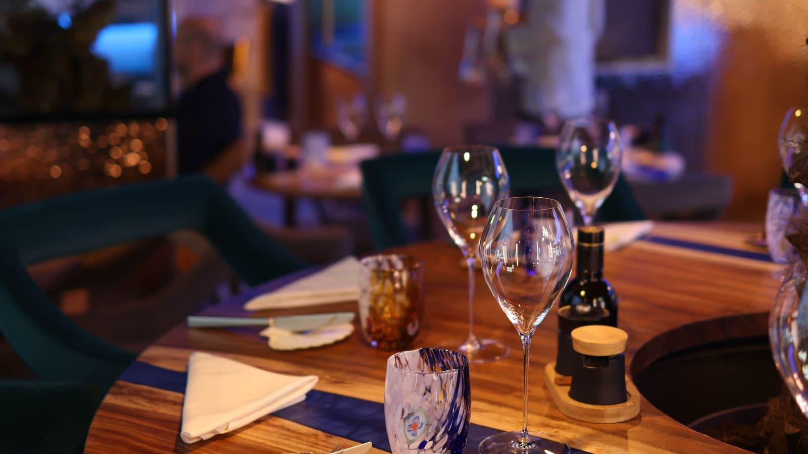 An intimate fine dining table set for dinner in a warmly lit restaurant