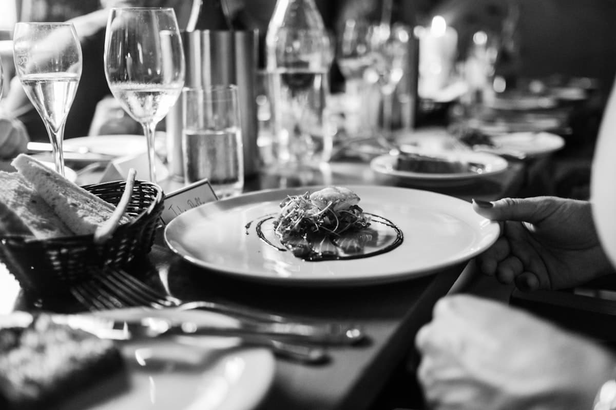 A stylish New York restaurant dining room with warm lighting and a crowded dinner service