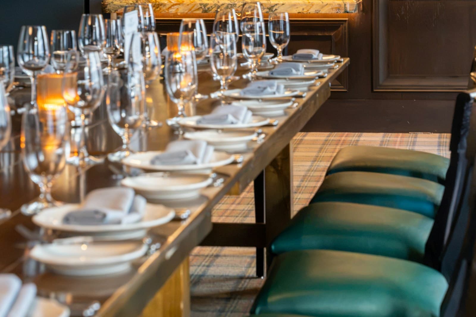 A long communal dining table set with glasses and napkins inside a San Francisco restaurant