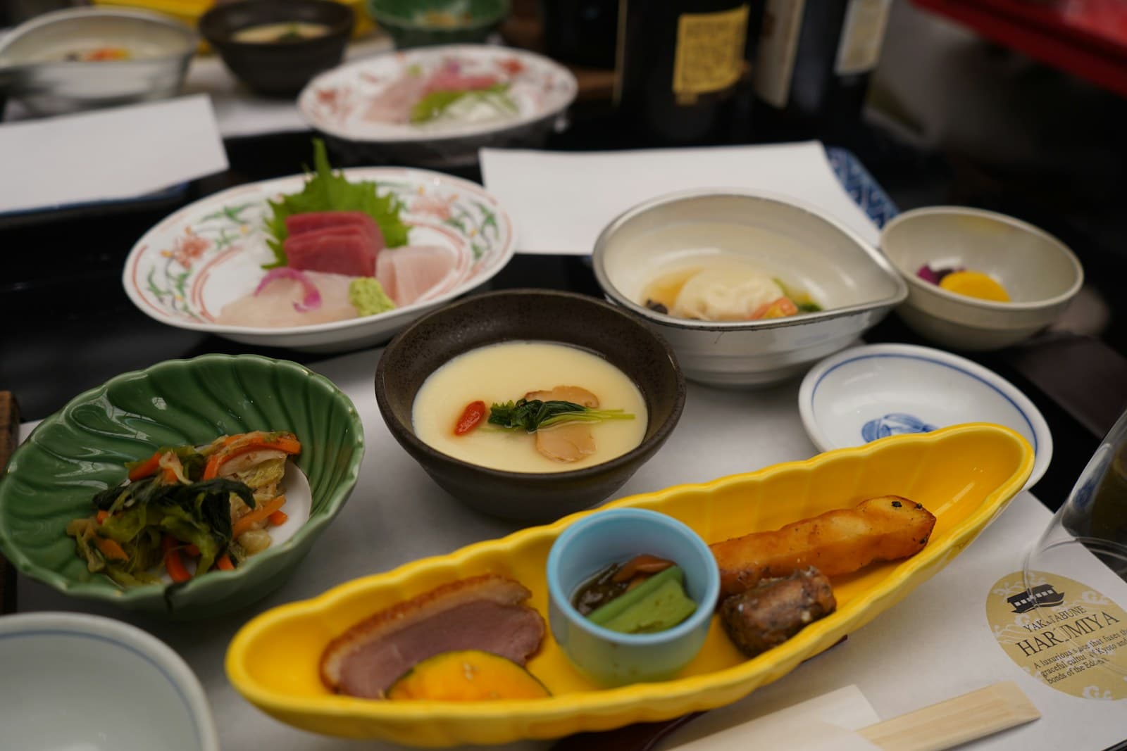 A Japanese multi-course dinner with small seasonal dishes arranged across a table