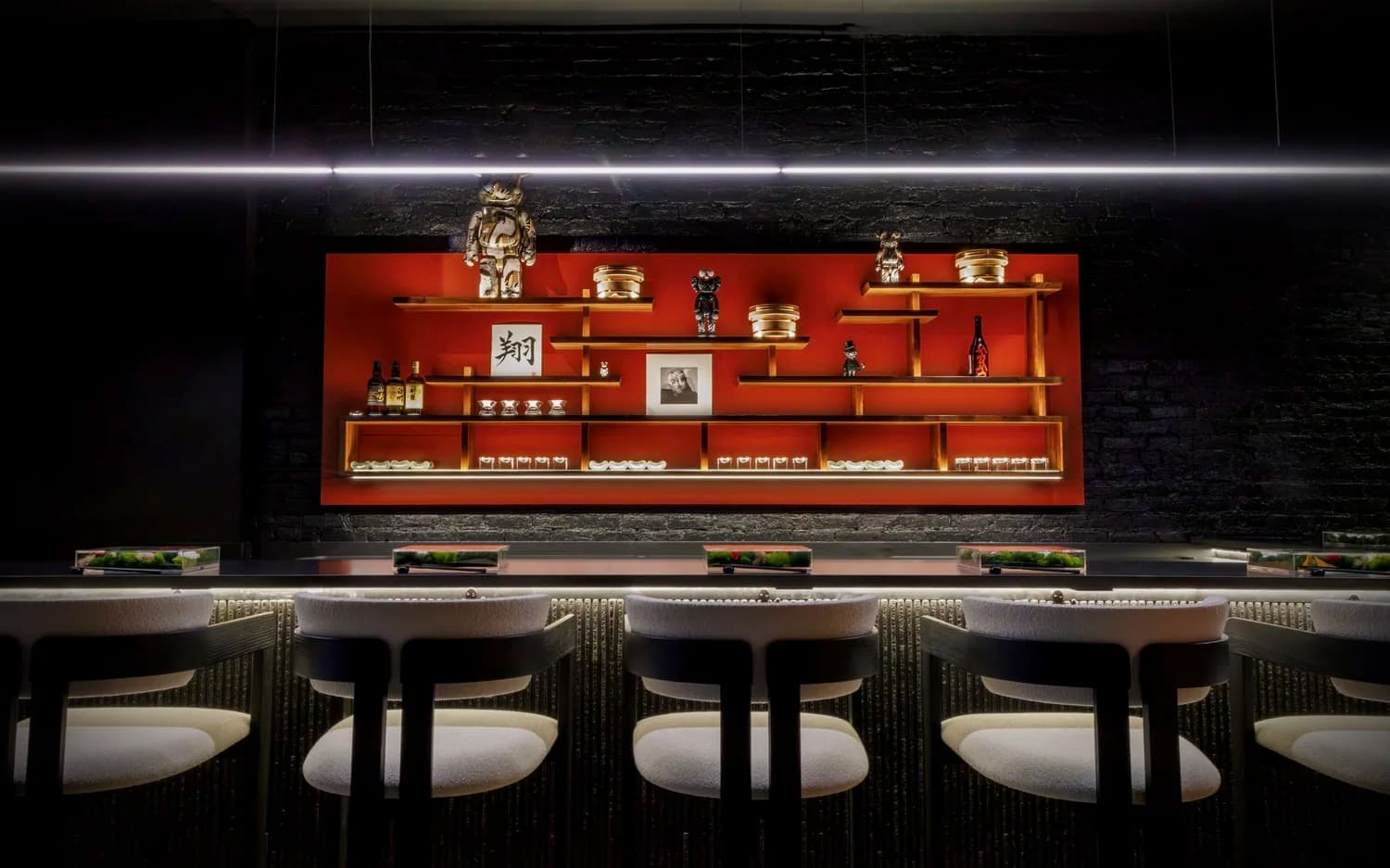 An omakase counter at SHŌ Chicago with plated courses and moody lighting
