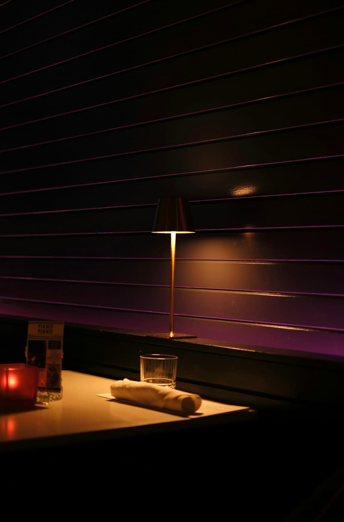 A moody American grill dining room with leather banquettes, cocktails, and candlelight in Georgetown
