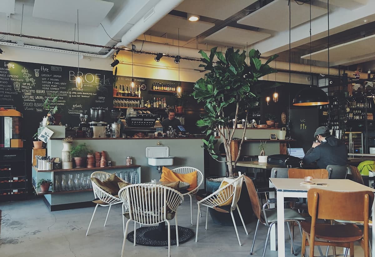 A colorful breakfast sandwich and coffee on a bright cafe table